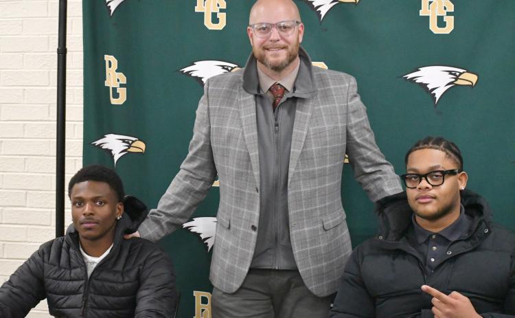 Wesley Branch/The Clayton Tribune. Rabun Gap head football coach Derek White (center) poses with Rabun Gap seniors CJ Willingham (left) and Devon Holly (right) on Feb. 5 at Rabun Gap’s signing day recognition for Willingham and Holly. Willingham will continue his football and academic careers at Columbia University, while Holly signed to North Carolina A&T.