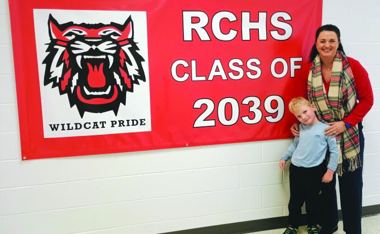 Megan Horn/The Clayton Tribune. Pre-K student Camdyn Darnell, 5, and Rabun County Primary School (RCPS) Principal Carla Truelove pose beside the “RCHS Class of 2039” sign that hangs in the Pre-K hallway. 2026-2027 Pre-K Lottery registration begins March 1 and ends March 13 at 4 p.m.