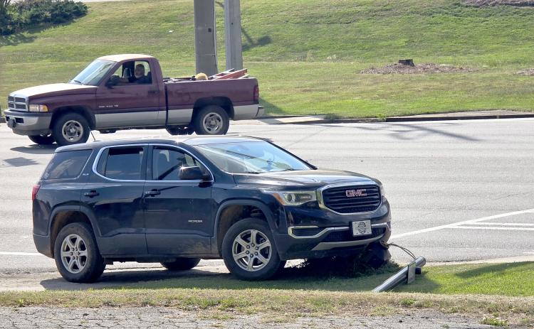 Enoch Autry/The Clayton Tribune. The vehicle that reportedly struck a U.S. 441 crosswalk sign is shown on top of the knocked down pole at the crash scene on April 23.