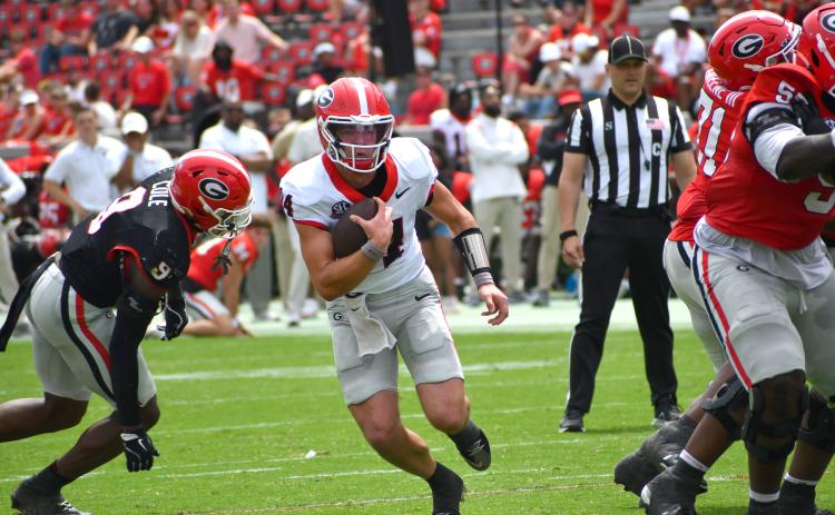 Wesley Branch/The Clayton Tribune. Current UGA and former Rabun County quarterback Gunner Stockton evades defensive pressure from the Black Team in Georgia’s ‘G-Day’ scrimmage. Stockton finished the afternoon 7-of-12 passing for 76 yards and a touchdown for the red team in a 27-17 victory.
