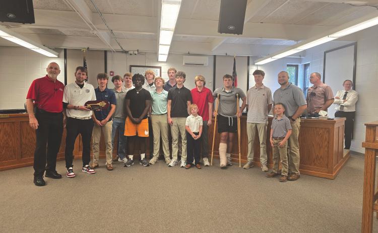 Enoch Autry/The Clayton Tribune. Clayton Mayor Roy Quilliams presents Rabun County head boys basketball coach David Adcock (far left) with a key to the city as the Wildcats stand in the front of the meeting room in city hall on May 12.