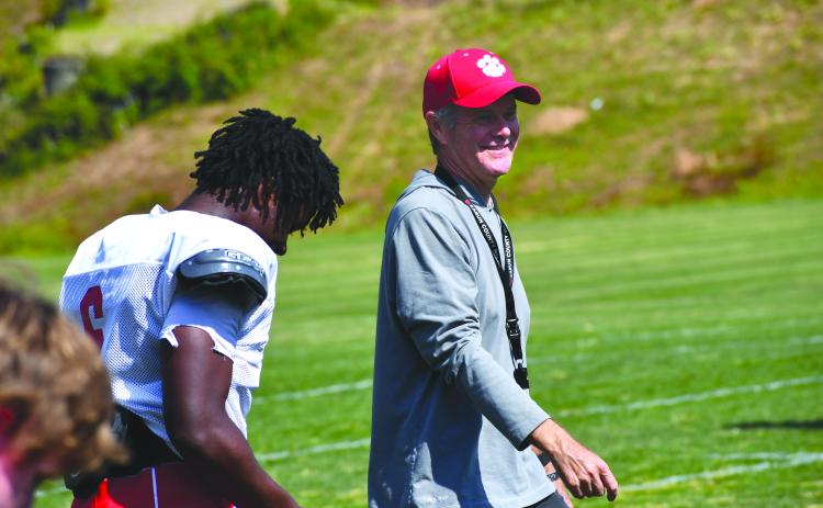 Wesley Branch/The Clayton Tribune. Rabun County High School head football coach Rance Gillespie smiles while chatting with rising senior linebacker JK Fruster during the Wildcats’ spring football practice on May 5. Gillespie is entering his second season as the head coach of RCHS, where he played in the 1980s.