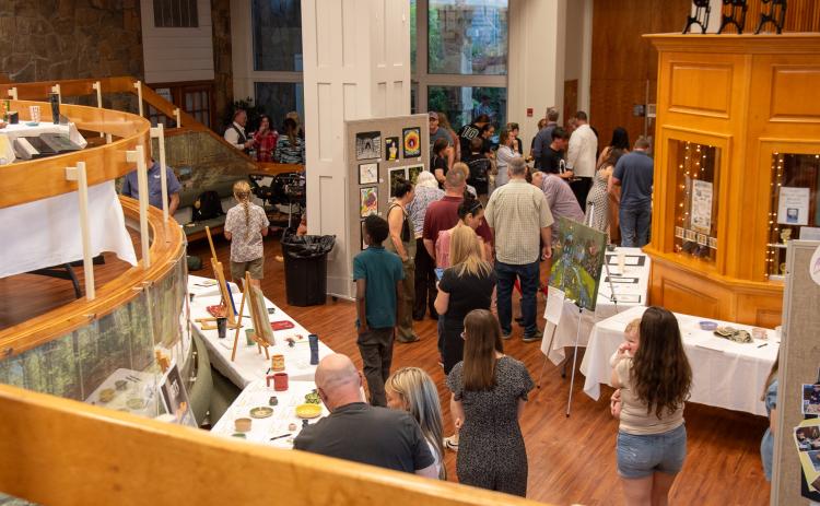 Photo courtesy of Elisha Boggs. Guests visit the Evening of the Arts packed with artwork, culinary art delights, demonstrations, music, and song.