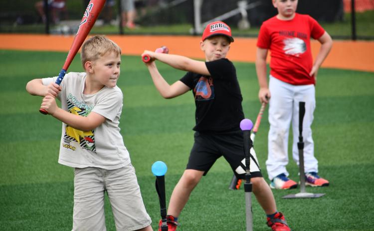 Wesley Branch/The Clayton Tribune. Campers practiced their swing on water-ballon like balls that exploded with water upon contact.