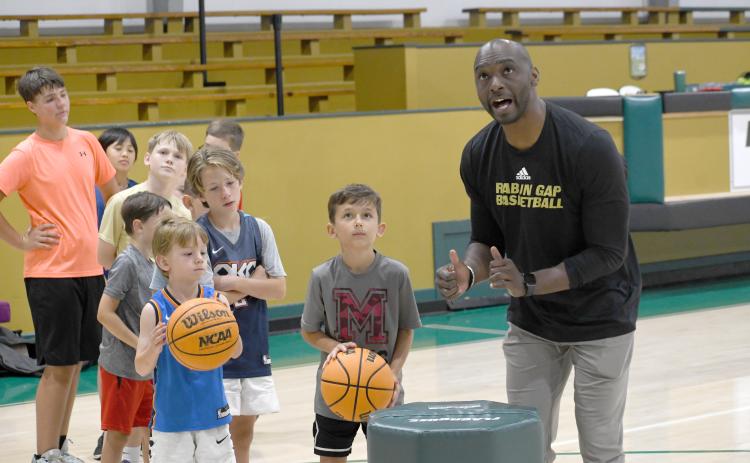 Wesley Branch/The Clayton Tribune. Rabun Gap-Nacoochee School head boys basketball coach Devin Liferidge leads campers in shooting drills during Rabun Gap’s kids basketball camp on June 8. Liferidge is entering his second season as the head boys basketball coach for the Eagles.
