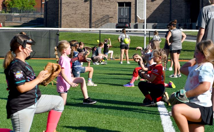 Wesley Branch/The Clayton Tribune. RCHS softball campers throw the ball to each other to warm up during the Rabun County softball camp at Rabun County High School on June 15. The camp was offered to kids aged 5-12 years old