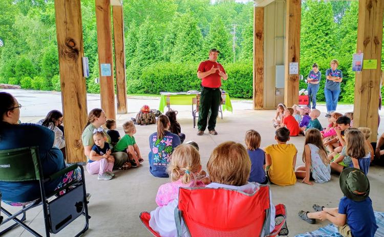 Megan Horn/The Clayton Tribune. Wildland Firefighter Thomas with the U.S. Forest Service talks to kids about fire safety and how to prevent forest fires during a Rabun County Public Library summer program event on Tuesday, June 9. 