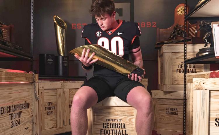 Image via Marcellus_yc on Instagram. Rabun Gap defensive lineman Marcellus Young Casario poses with a national championship trophy during his official visit to Georgia. Casario announced his commitment to the Bulldogs on June 15.  