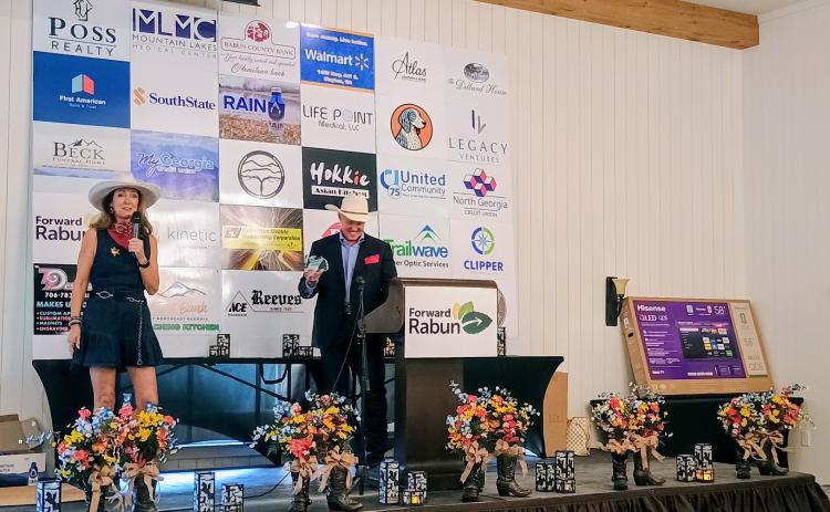 Megan Horn/The Clayton Tribune. Brenda Patterson, owner of White Birch Inn, White Birch Provisions and The Watchmaker’s Workspace, received the 2026 Entrepreneur of the Year award. Patterson thanked the community for their support. She stands on stage with Forward Rabun President Rick Story.