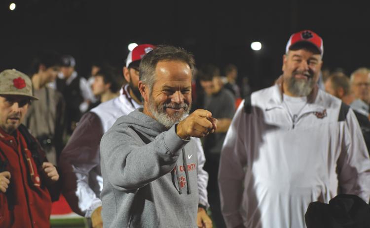 Wesley Branch/The Clayton Tribune. Rabun County head football coach Rance Gillespie celebrates with his team after the Wildcats’ 35-0 second-round playoff win over Berrien on Nov. 21, 2025. Gillespie and the Wildcats have celebrated each win at home with the song “It’s a Great Day to Be Alive,” since former head coach Lee Shaw started the tradition in 2013. Standing in the background are Manager Josh Justus, Pastor Lance Courtney and current Rabun County Athletics Booster Club President Joey Haban.
