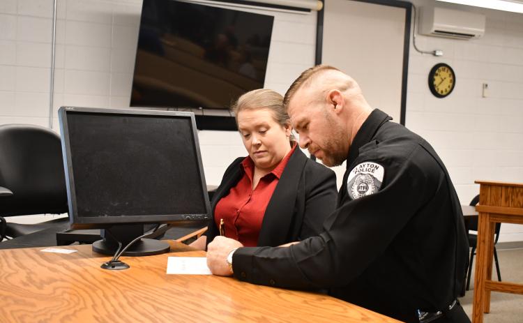 Megan Horn/The Clayton Tribune. Newly sworn-in Clayton Police Chief Kevin Marsteller, right, signs paperwork next to Rabun County Probate Judge Savannah Dixon after administering the Oath of Office to Marsteller on Thursday, Aug. 27, in the courtroom at Clayton City Hall.