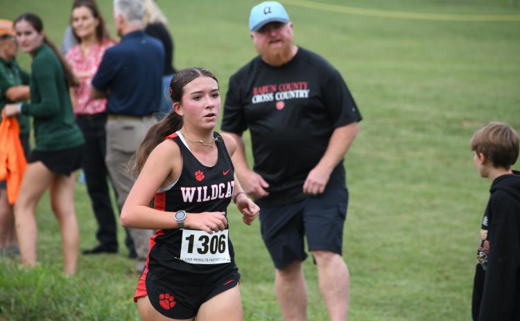 Wesley Branch/The Clayton Tribune. Rabun County sophomore Kinley Jones runs during the Harrier Harvest meet at Tallulah Falls School on Sept. 24 as her father Brandon cheers her on. Jones was the top finisher overall for the girls with a time of 21:10.77.