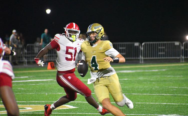 Wesley Branch/The Clayton Tribune. Rabun Gap quarterback Grayson Clary evades Baylor defenders during Rabun Gap’s 51-33 loss to Baylor on Sept. 4. Clary threw for 413 yards and scored three total touchdowns in the Eagles’ loss.