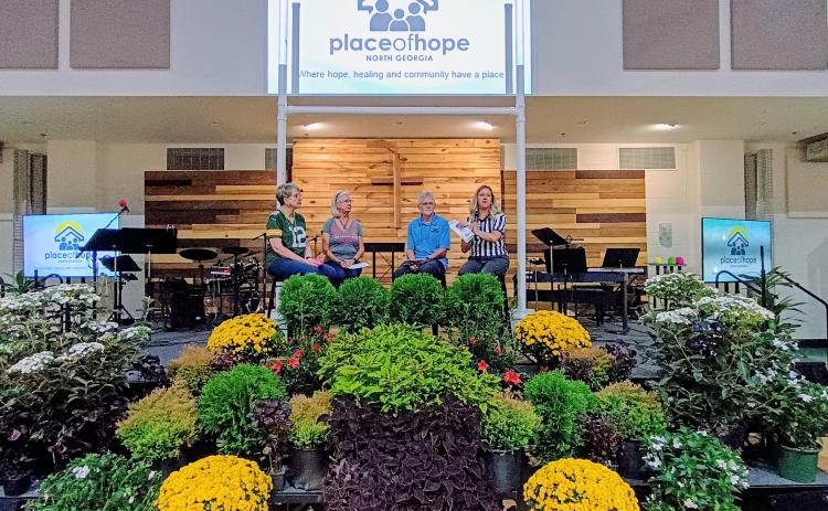 Megan Horn/The Clayton Tribune. Place of Hope North Georgia volunteers Teri Gottschalk, Ned Luczynski and Barbara Cantrell speak about experiences they have had with foster children who impacted their lives in positive ways. Also pictured at the “Picnic for a Purpose” event is Executive Director Elizabeth Adams.