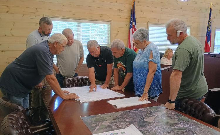 Megan Horn/The Clayton Tribune. Lead Pastor of River Point Rabun Community Church, other church officials and Tiger Town Council members look at preliminary site plans for a new church building to potentially be built in city limits during the Aug. 10 council meeting.