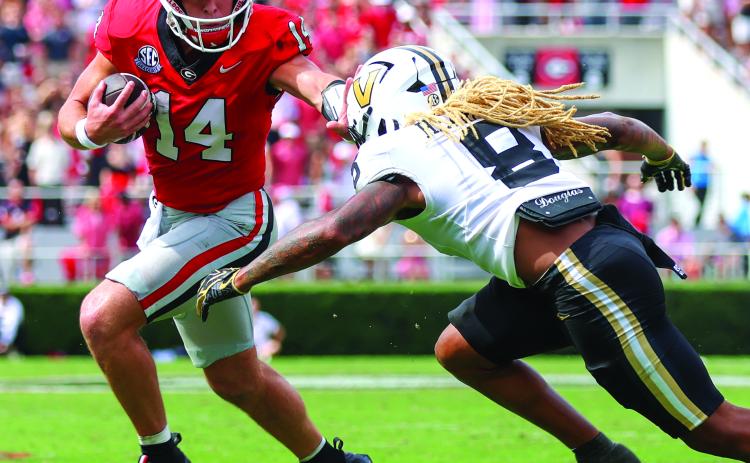Landen Todd/CNI News Service. Georgia quarterback and Tiger resident Gunner Stockton stiffarms Vandy’s CJ Heard as the senior rushed seven times for 22 yards in Georgia’s SEC win. No. 2-ranked UGA faces No. 6 Alabama on Saturday.