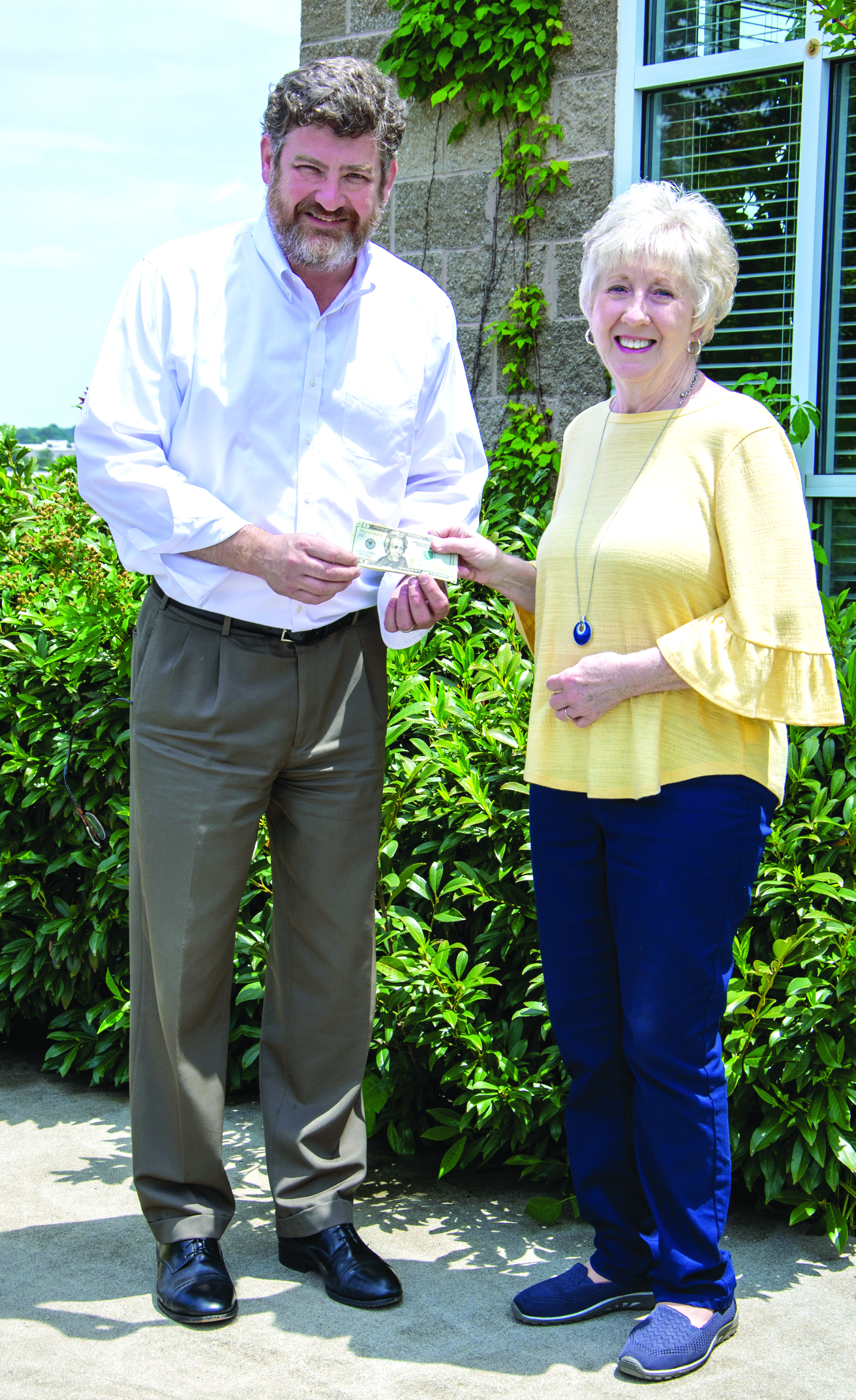 Photo courtesy Kimberly Brown. Cornelia resident Donna Shirley receives her $100 prize money from Alan NeSmith, Community Newspapers Inc. chairman. Shirley’s photograph of the double waterfalls at Anna Ruby Falls graces the cover of the 2023 summer edition of The Mountain Traveler magazine.