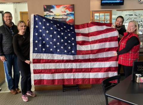 Submitted photo. Pictured (from left) are Adam Dixon, Woodmen Sales Rep; Sydni Cooper, server; Stanley Cooper, Chef and son of Duncan; Carolyn Dillard, Woodman Member and Sponsor of flag donation.