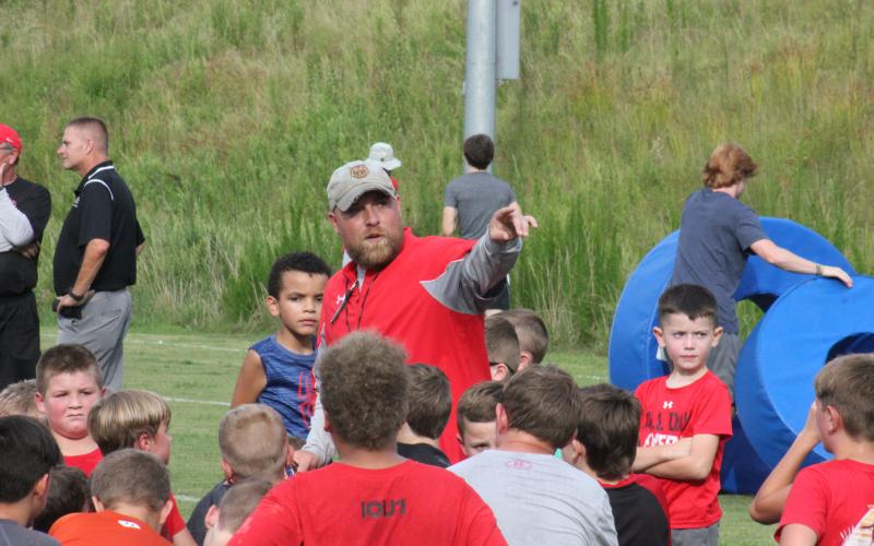 Rabun County running backs coach Andy Mahaffey directs players toward the next position station during the football team’s Future Wildcats Camp at the team’s practice field in Tiger on Monday night. (Glendon Poe/The Clayton Tribune)