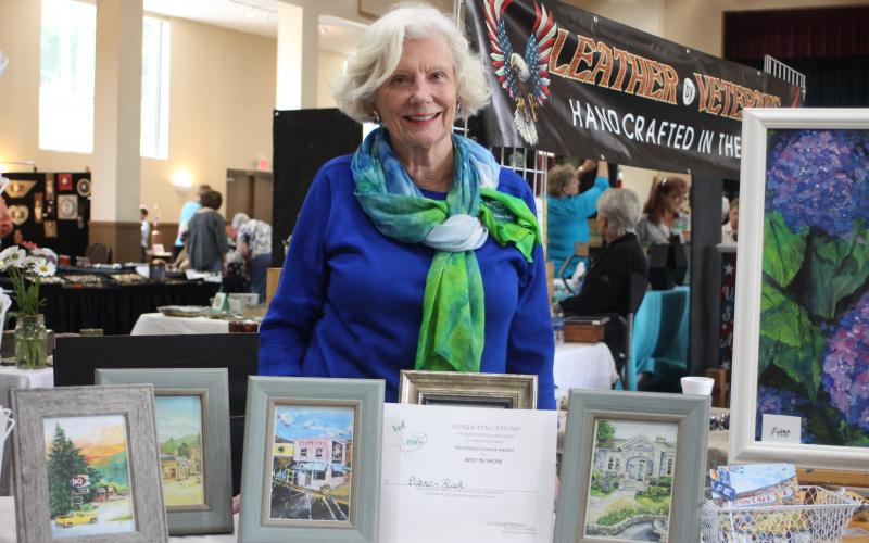 Diane Rush displays her certificate for winning "Peoples Choice Award" for her paintings of historic buildings of Rabun County at the Painted Fern Festival of Art hosted by the North Georgia Arts Guild at the Rabun County Civic Center on July 13-14.