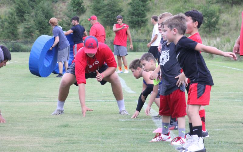 Rabun County junior Bear Old demonstrates proper offensive lineman technique during the football team’s Future Wildcats Camp at the practice field in Tiger on Monday night. (Glendon Poe/The Clayton Tribune)