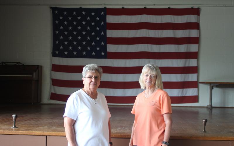 Grace Watts, mayor of Mountain City, left, and Brenda Cannon, city clerk, stand in front of the stage on new flooring at Mountain City's city hall where the Bicentennial square dance will take place on Saturday, July 20