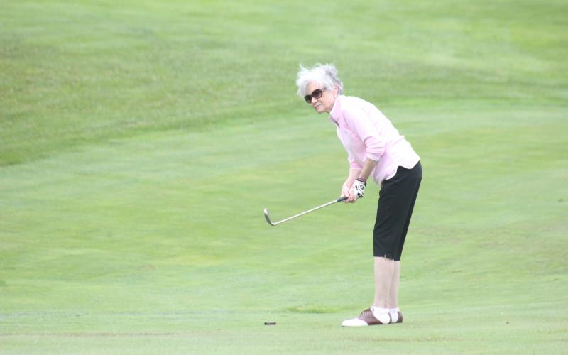 Pam Spears chips a shot onto the green during the Sid Weber Memorial Cancer Fund golf tournament at Sky Valley Country Club last Wednesday. (Photo by Glendon Poe/The Clayton Tribune)
