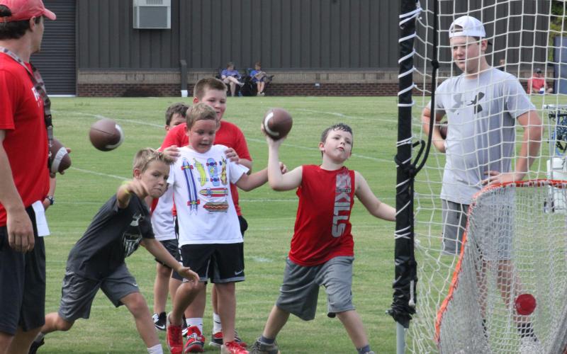 Campers throw footballs during a drill at Rabun County’s Future Wildcats Camp at the team’s practice field in Tiger on Monday night. (Glendon Poe/The Clayton Tribune)