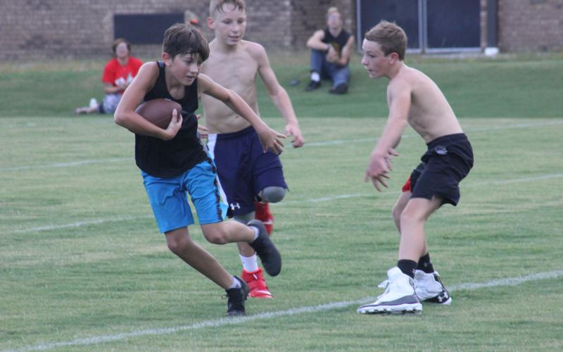 Campers play two-hand touch football during the Future Wildcats Camp at the football practice field in Tiger on Monday night.