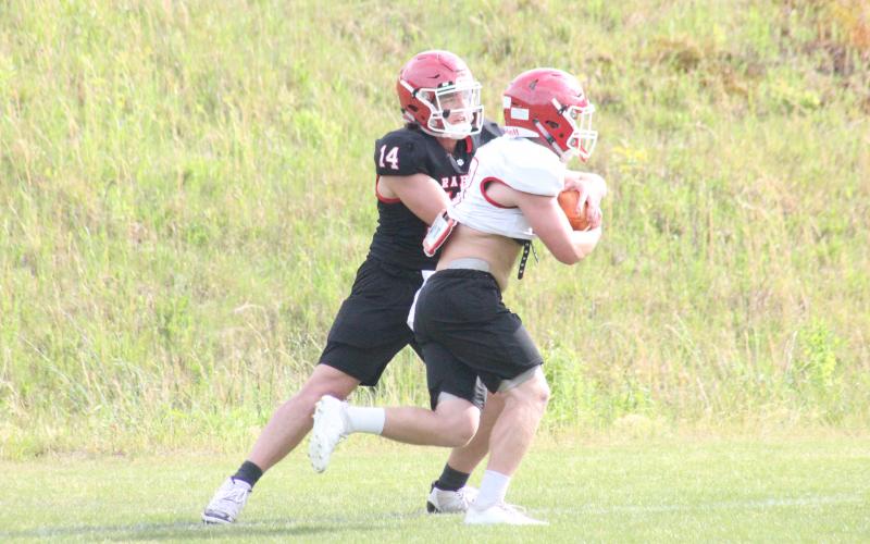 Rabun County quarterback Gunner Stockton, left, hands the ball off to running back Brody Jarrard during a practice in May. (Glendon Poe/The Clayton Tribune)