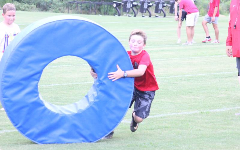 Campers take turns performing a tackling drill at Rabun County’s Future Wildcats Camp at the team’s practice field in Tiger on Monday night. (Glendon Poe/The Clayton Tribune)