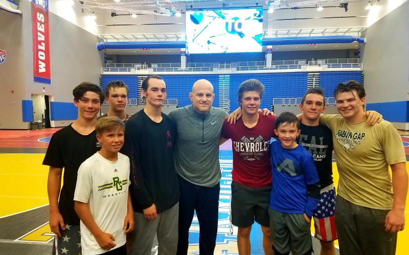Nolan Conrad of Clayton, Charlie Hall of Long Creek, S.C., Aiden McMullen of Highlands, N.C., Cole Owens of Conyers, Cael Sanderson (Penn State coach), Aidan Loring of Clayton, Brody Fon of Franklin, N.C., Matt Campbell of Highlands, N.C., and Quill Martin of Clayton are pictured. (Photo courtesy of Rabun Gap-Nacoochee School)