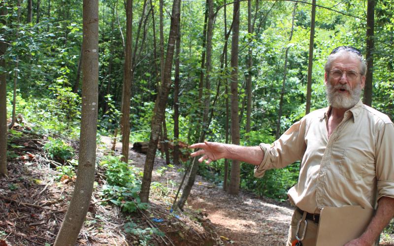 Megan Broome/The Clayton Tribune. Buzz Williams, program associate for Chattooga Conservancy, points out rare plants and native vegetation in Stekoa Creek Park, located near Stekoa Creek, as he talks about the history of the park.
