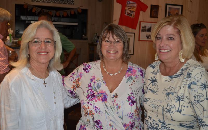 Wayne Knuckles/The Clayton Tribune. Tourism Development Authority Executive Director Teka Earnhardt, center, is greeted by Daphne Lisenby of Wolffork Valley Farms (left) and TDA board vice-chairman Laura Gurley at a reception Tuesday at Clayton Café.