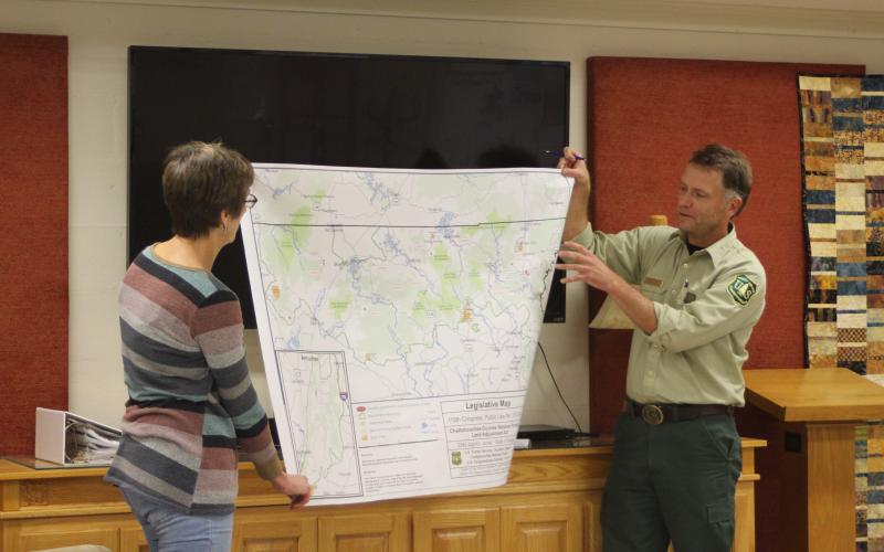 Megan Broome/The Clayton Tribune. Marie Dunkle, board president for Georgia ForestWatch, left, and Ryan Foote, district ranger for the Chattooga River Ranger District of the Chattahoochee-Oconee National Forest in Lakemont, hold up a map of National Forest System Land in Georgia potentially for sale. Foote points to the location of Rabun County, where approximately 1,229 acres of the roughly 3,841 acres is located.