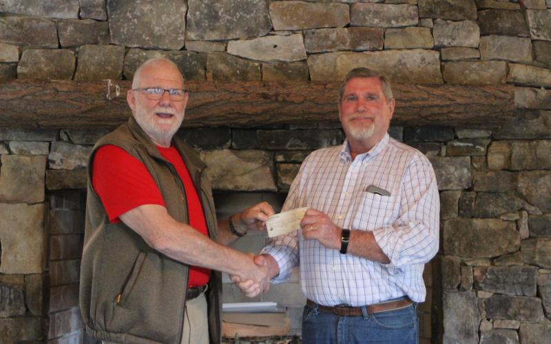 Megan Broome/The Clayton Tribune. Rocky Ford, left, President of Rhapsody in Rabun, presents a check to Dan McAfee, President of Habitat for Humanity of Rabun County, from the proceeds of the Rhapsody in Rabun Gala at an event held at the Lake Rabun Pavilion recently.