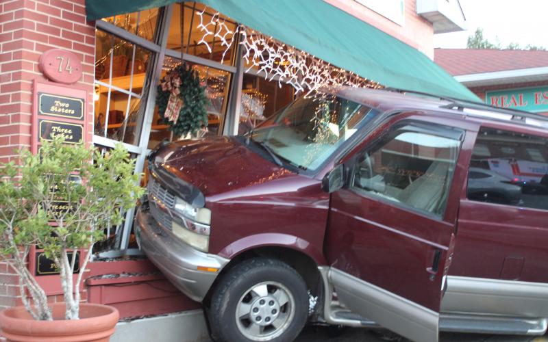 Megan Broome/The Clayton Tribune. A van crashed into the outside of Butler Galleries on Main Street in Clayton on Dec. 11. A Mountain City man was taken to Northeast Georgia Medical Center for treatment as a result of the accident. 