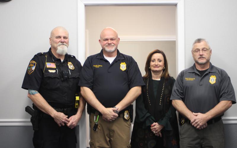 Megan Broome/The Clayton Tribune. Lt. Ron Baumes, police officer, left, Vaughn Estes, chief of police, Ella Fast, city manager and Lt. David Edwards, police officer, stand inside the newly renovated Sky Valley Police Department building at an open house for the City of Sky Valley on Thursday, Dec. 19. Edwards completed the renovation project. 
