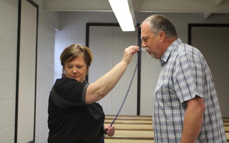 Megan Broome/The Clayton Tribune. Lt. Misty Houston, left, takes the temperature of Council Member John Bradshaw before Monday's special called Clayton City Council meeting discussing COVID-19 concerns. 