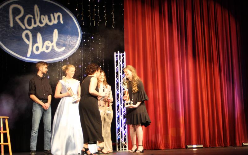 Megan Broome/The Clayton Tribune. Garrison Matlock, left, fourth place, Hailey Smith, second place, Taylor Erlewine, third place, and Hannah Thompson, first place, are handed their respective trophies by Kaylin Gragg at the last performance of Rabun Idol.