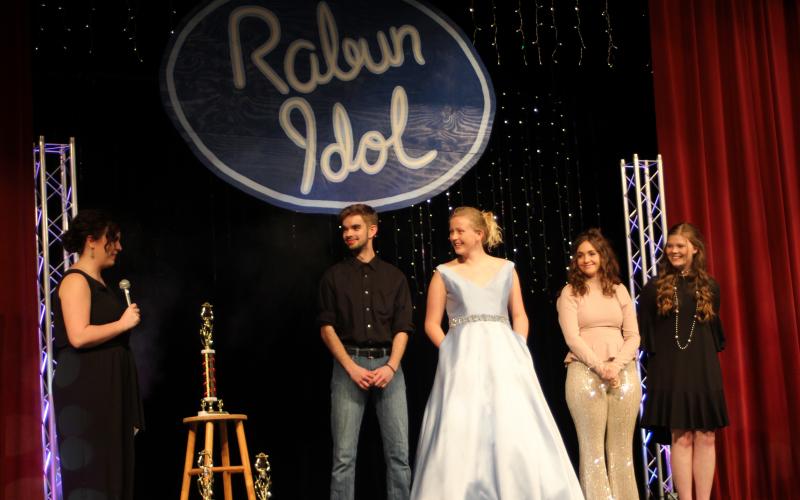 Megan Broome/The Clayton Tribune. Garrison Matlock, left, fourth place, Hailey Smith, second place, Taylor Erlewine, third place, and Hannah Thompson, first place, are handed their respective trophies by Kaylin Gragg at the last performance of Rabun Idol.