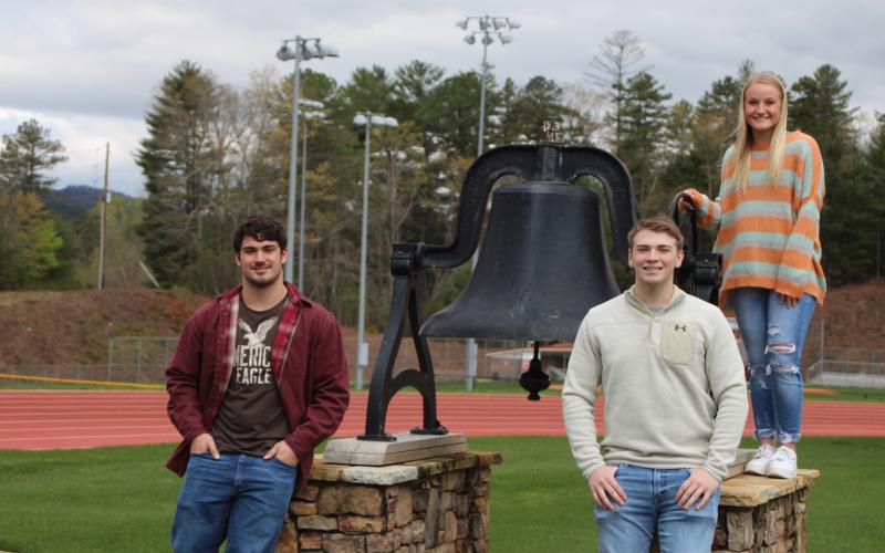 Megan Broome/The Clayton Tribune.Rabun County High School’s top three students stand by the large bell on the football field that is rung at graduation each year. Mason Sprinkle, left, is Historian, Will Hightower is Salutatorian and Ali Ramey is Valedictorian for the 2019-2020 academic year.