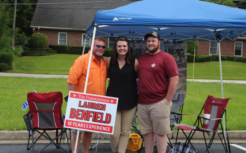 Megan Broome/The Clayton Tribune. Brian Talley, left, Candidate Lauren Benfield and Jordan Benfield camp out in the parking lot across from the Civid Civic Center and spend Tuesday greeting voters as they head to the polls for the primary election. 