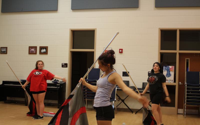 Color guard members Desirhae Buice, left, Tiffani Dobson and Kristin English practice during sectionals at band camp last week.