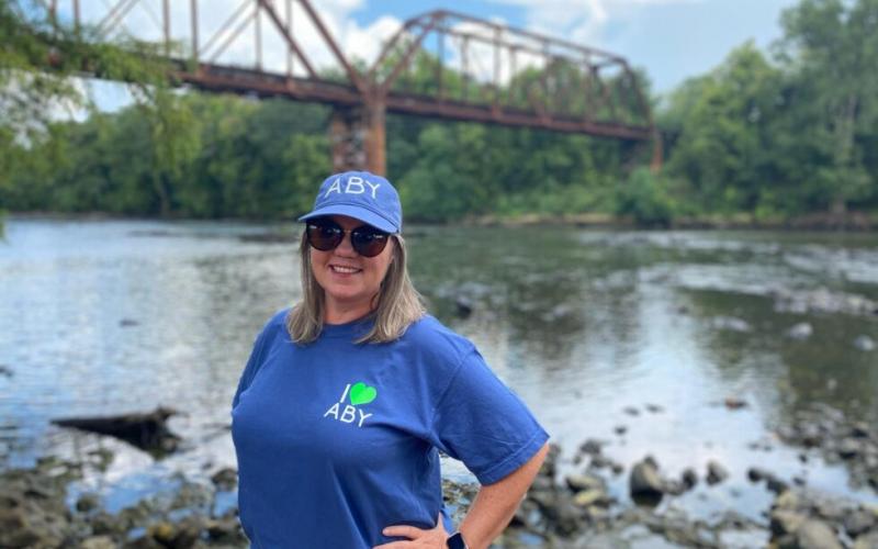 Photo from Capitol Beat News Service website. Rashelle Beasley, director of the Albany Convention & Visitors Bureau, models I Love ABY tourism promotion merchandise