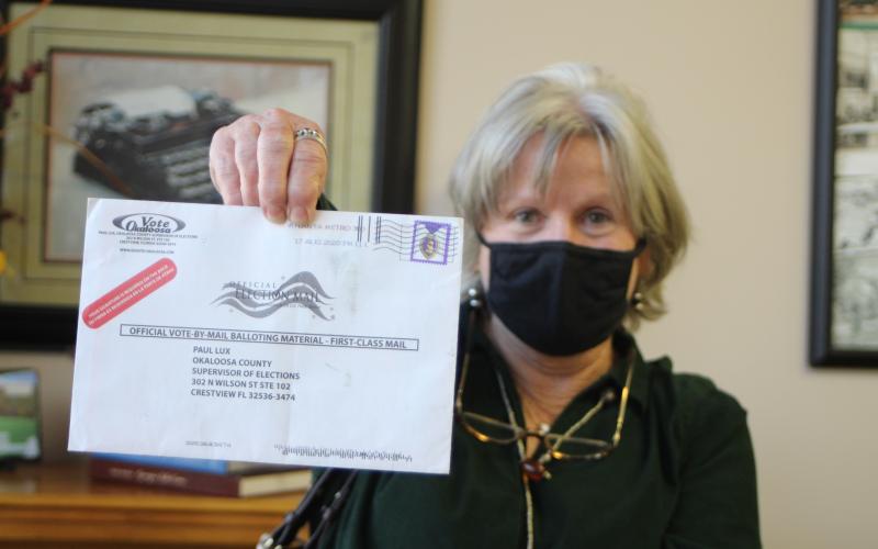 Megan Broome/The Clayton Tribune. Voter Pamela Wawrzyk holds up an absentee ballot that was returned by the post office for an unknown reason. She said that she and her husband Stephen found the ballot in their mailbox when they came back from Florida and it had no indication of the reason it was returned. She cautioned voters to be sure and check their ballot status to make sure their ballot is received by the elections office for their vote to be counted. 