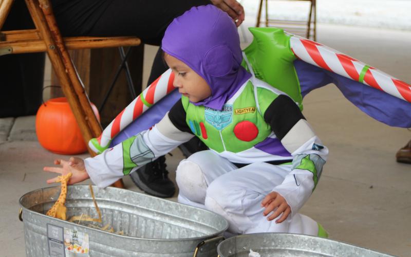 Megan Broome/The Clayton Tribune. Daniel Contreras dresses as Buzz Lightyear and plays one of the games at the Fall jamboree in Clayton Halloween night. 