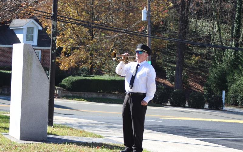 Megan Broome/The Clayton Tribune. Bugler Danny Stephens plays taps after the Honor Guard gives the 21-gun salute at the conclusion of the ceremony. 