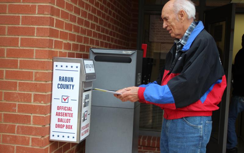 Megan Broome/The Clayton Tribune. Voter J.P. Miles returns his absentee ballot to the designated box in front of the Board of Elections Office on Monday. The office is located at 18 Old Raco Dr., Suite 105, Clayton. 