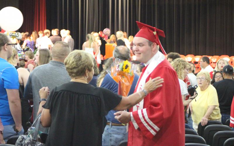 Megan Broome/The Clayton Tribune. Graduate Simon Bass hugs friends and family members after graduating with the Class of 2021 at a ceremony held in the Fine Arts Building last Friday. 